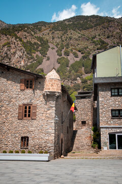 Historic stone building of Casa de la Vall in Andorra la Vella Old town with Pyrenees mountains in the background on a sunny day