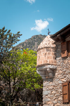 Historic stone building of Casa de la Vall in Andorra la Vella Old town with Pyrenees mountains in the background on a sunny day