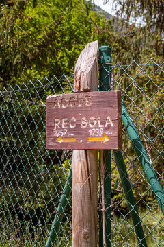 Wooden sign on Rec del Sola Trail in Andorra la Vella on a sunny day
