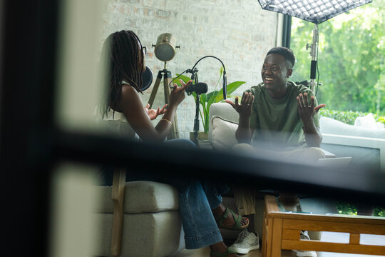 Broadcast microphones are capturing lively conversation in studio living room with softbox light