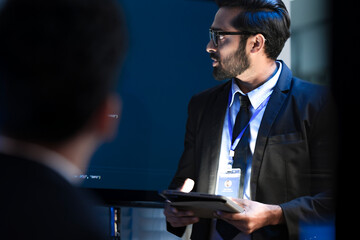 A tech expert, an Indian man, presents a new AI-driven software solution at a business summit. He...