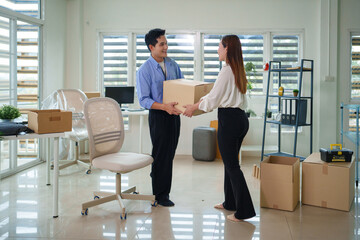 Fototapeta premium Asian adult business people relocating office space carrying supplies furniture together new workspace setup partnership professional move