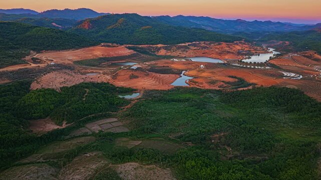 Aerial drone view of Tad Ma Waterfall in Vientiane, Laos, surrounded by vast rice terraces and fertile farmland nourished by abundant water resources.