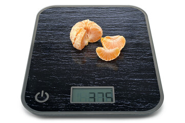 Fresh tangerine on digital kitchen scales