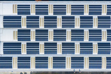 Fototapeta premium Aerial view directly above Solar panels on the roof of a station mall building