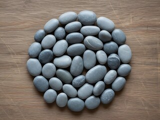 Collected smooth pebbles forming a circle on a rustic timber surface