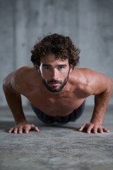 Obraz premium Young caucasian male engaged in push-up exercise in urban setting