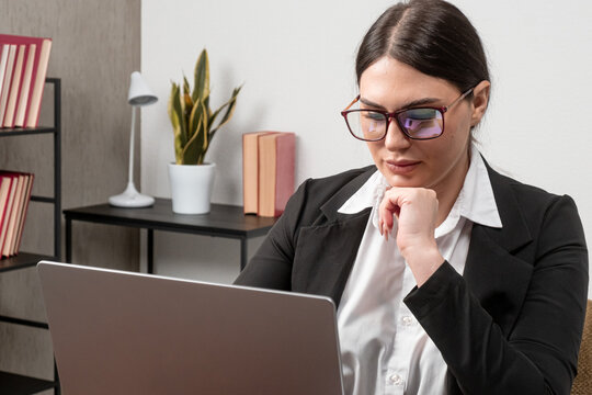 Corporate strategist in glasses planning digital expansion strategy on laptop. Business productivity concept.
