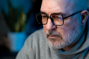 Professional data analyst working late at computer with serious and focused expression. Modern digital work concept.
