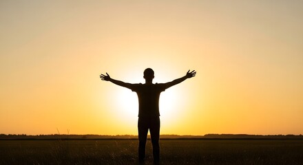 Fototapeta premium Silhouette of Man with Open Arms at Golden Sunset in Open Field