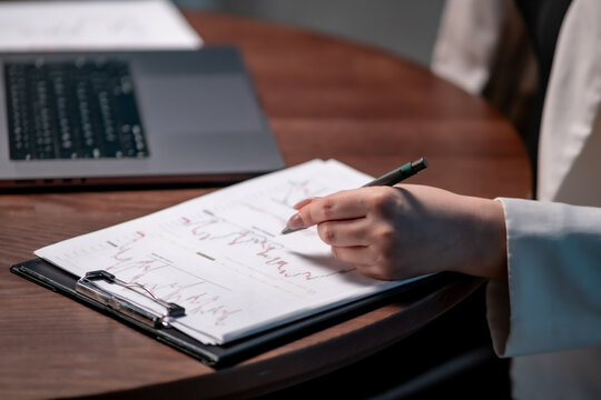 Businesswoman preparing financial forecast in evening office with laptop. Financial forecasting concept
