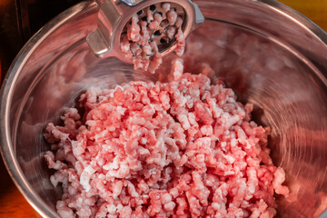 Ground pork chopped by meat grinder in stainless steel bowl