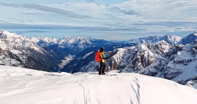 Aerial footage of a ski mountaineer in a snowy alpine ridge in Dolomites. Winter landscape, backcountry adventure, and solitude in breathtaking mountain scenery captured in 4K.