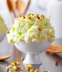 Pistachio ice cream with nuts and a cinnamon stick