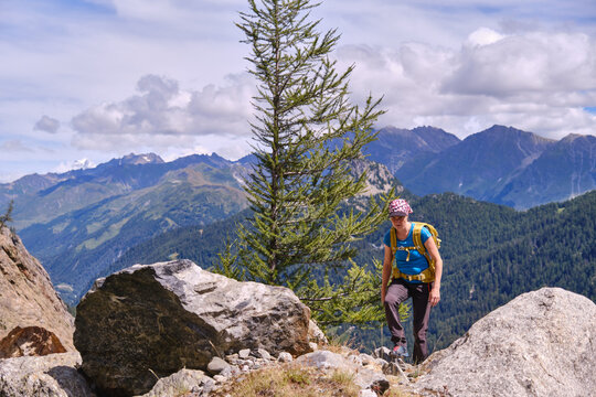 Woman hiker walking among rocks in the mountains