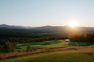 Obraz premium Scenic mountain golf course at sunset with rolling hills and water feature
