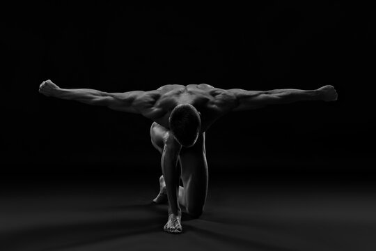 Artistic muscular man with outstretched arms like wings, black and white