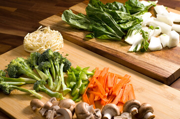 Cut Ingredients, Carrots,Mushrooms,Broccoli,Pasta, Bok Choy and Green Peppers Ready to Make a Stir Fry on Wood Cutting Boards