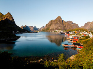 Naklejka premium Inner Harbour of Reine – Iconic Red Fisher Houses on a Sunny Day in Lofoten