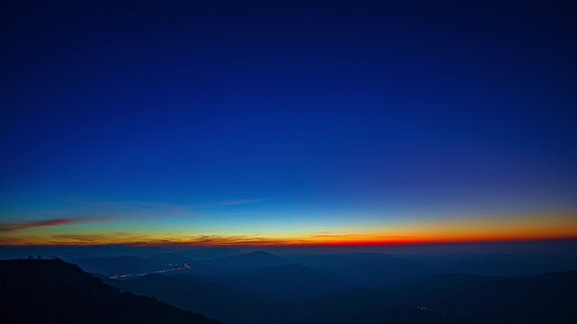 Gentle rays rise above the distant ridges, illuminating the wilderness with a warm morning shimmer. This time lapse showcases the peaceful beauty of a mountain sunrise spreading across the horizon.