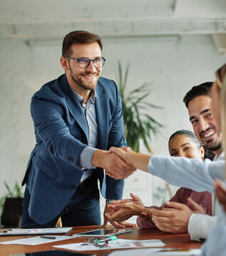 Group of young business people having a meeting shaking hands handshake introducing each other during meeting in the office. Teamwork and success concept