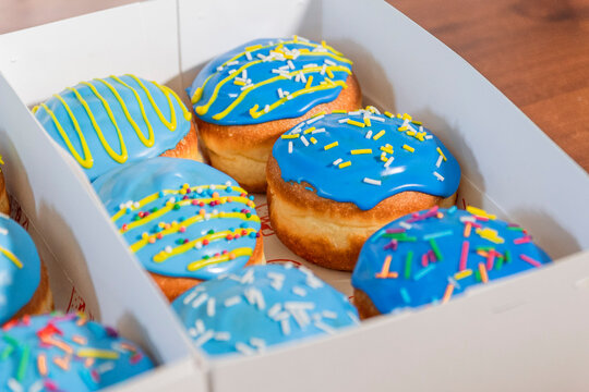 Caja de donas con glaseado color azul y chispas amarillas. 
