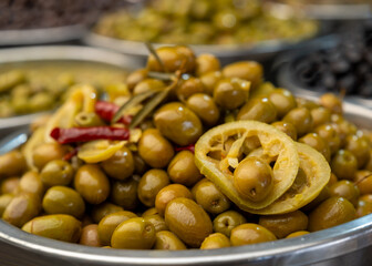 Fresh Green Olives with Lemon Slices in a Market Bowl
