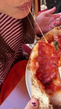 Happy girl pulling flexible mozzarella with delicious toppings visible