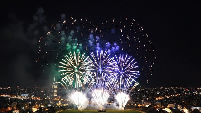 Colorful fireworks exploding over illuminated city at night