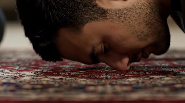 Close up of a Muslim man performing prostration on a prayer rug. Young man in Sujud position during Islamic prayer. Religious worship and faith concept