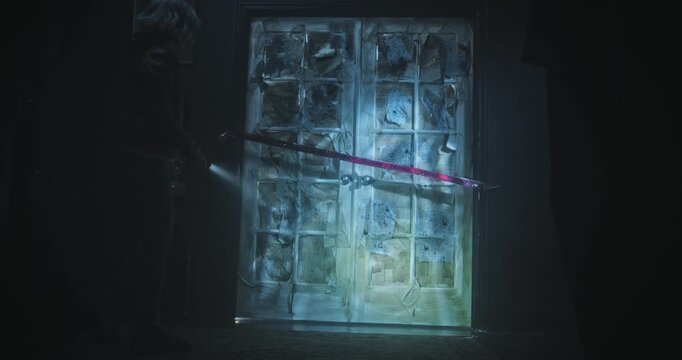 Young woman with flashlight entering spooky door in scary house - wide, dolly in