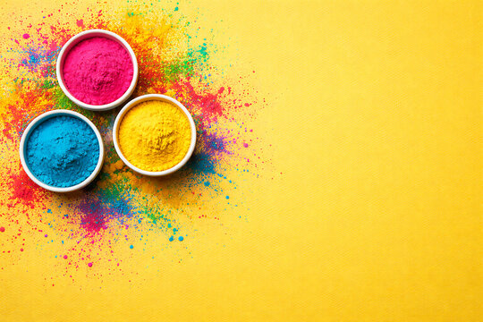 Top view of three bowls containing pink blue and yellow colorful powder on vivid yellow background representing holi holika dhan and rang panchami celebration concepts