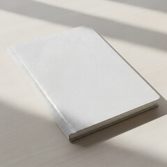 Fototapeta premium Image of a blank white notebook on the table with soft shadow, perfect for design element 