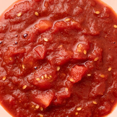 Obraz premium Macro close up of thick chunky red tomato sauce with visible seeds and glossy wet surface
