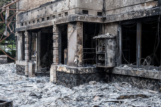 View of a building reduced to rubble after being burned by protesters during riots fueled by anger.