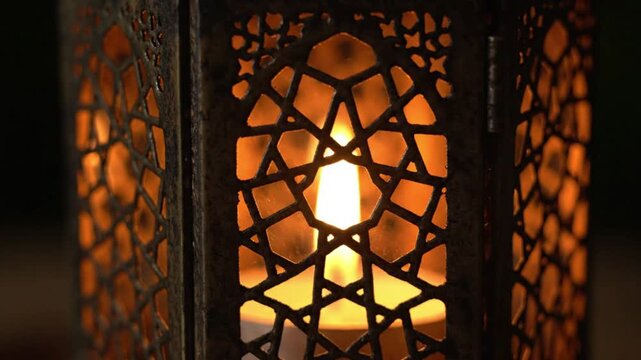 Close-up of a beautiful ornate lantern with a glowing candle inside, creating a warm, ambient light.