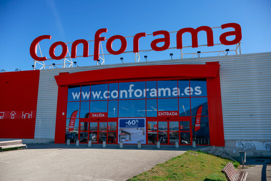 Pamplona, ​​Spain - February 23, 2026. A Conforama store with a large red sign at the top, the building features a white structure with red details, wide glass doors at the entrance and exit,
