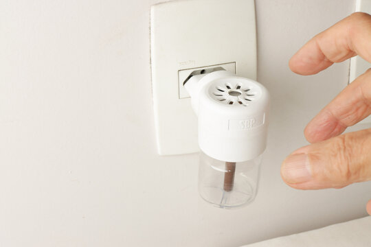 Man Plugging in An Electric Plug in Mosquito Repellent for home use