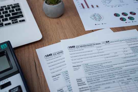US Individual Income Tax Return Form 1040 with US Dollars and Laptop for Tax Season Concept