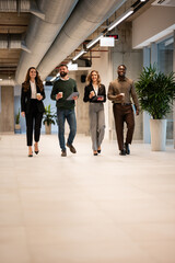 Obraz premium Diverse business colleagues walking in modern office hallway