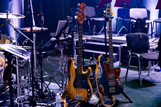 Professional Fender and Fano Bass Guitars on Stage with Drum Kit Background