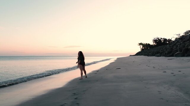 woman doing cartwheel on ocean beach in panama