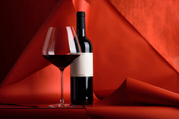 Red Wine Bottle and Glass on Red Background. Elegant Festive Still Life