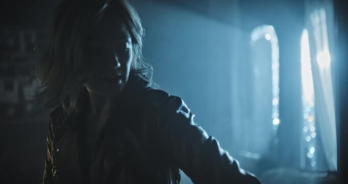Silhouette of woman entering spooky, foggy room then stopping door from closing behind her - handheld, medium shot