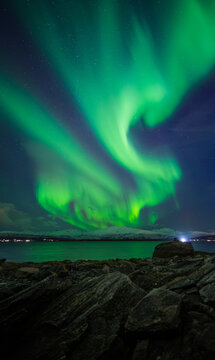 l'aurora boreale si mostra sul mare, vista dalla citt&agrave; di tromso