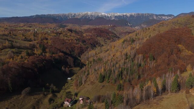 Stunning Autumn Pestera Village Valley under Snow Capped Piatra Craiului Mountains Aerial High Altitude Flight 4K Graded