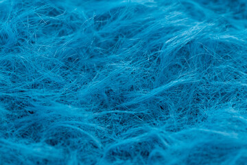 Macro shot of soft blue mohair wool texture. Close-up of fuzzy and fluffy blue yarn fibers for knitting and textile background. © Anna Kondratiuk