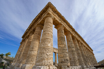 Fototapeta premium Wide Low-Angle View of the Doric Temple of Segesta Against a Dramatic Blue Sky with White Clouds, Sicily