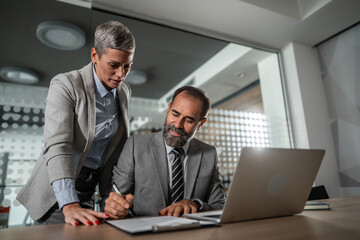 Obraz premium Business colleagues collaborating on document in office meeting