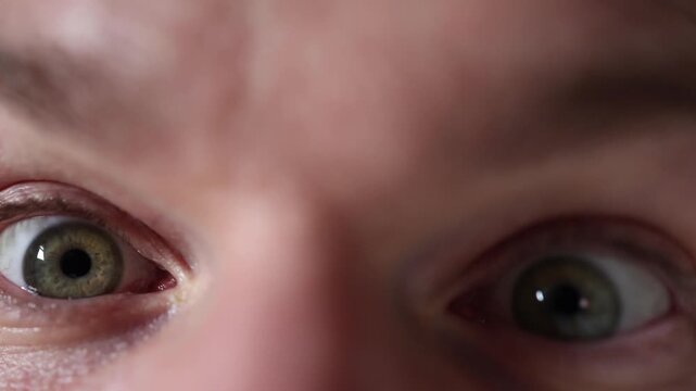 Closeup shows wide surprised eyes with raised eyelids and heightened focus revealing natural skin detail and expressive reaction capturing a realistic moment of sudden astonishment in macro